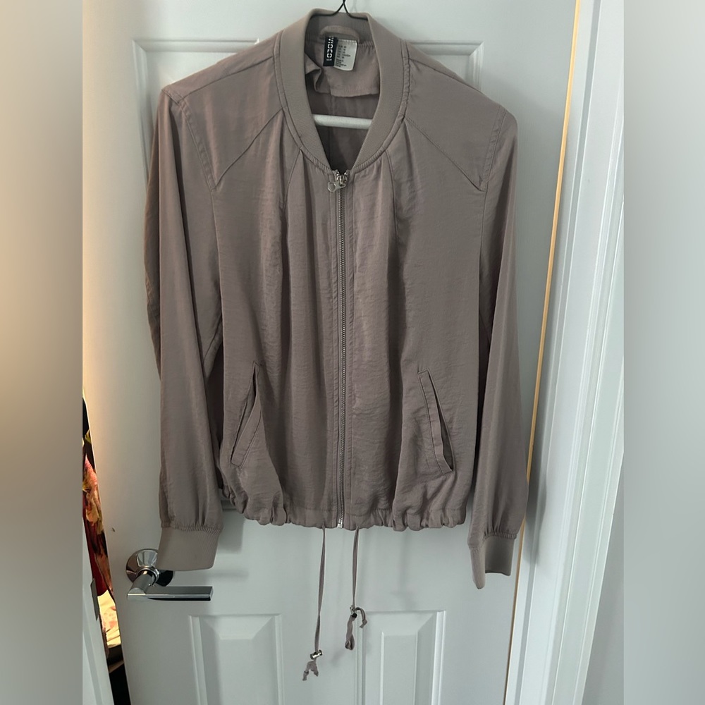 Mauve zip-up bomber jacket with drawstring at the bottom.